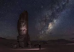 نمای بیابان در شب با تماشا صخره ها و ستاره ها